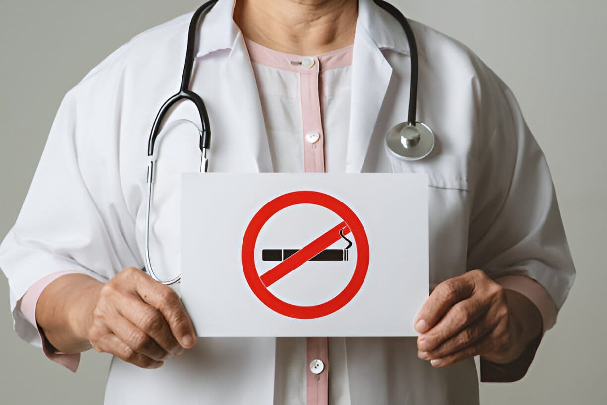 doctor is holding a no smoking poster