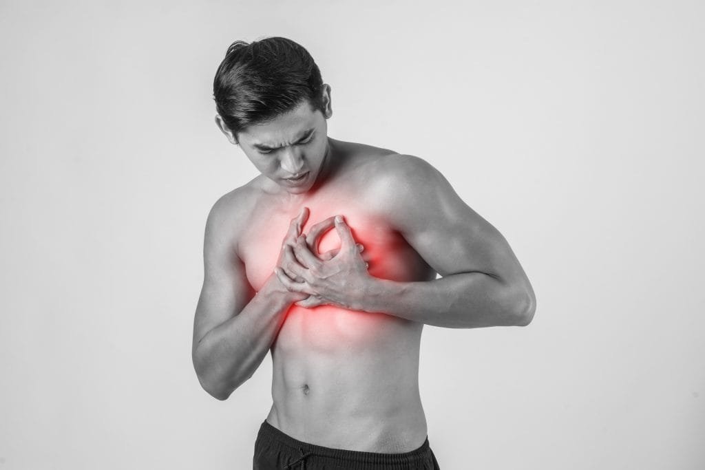 Young man has heart attack isolated on white background